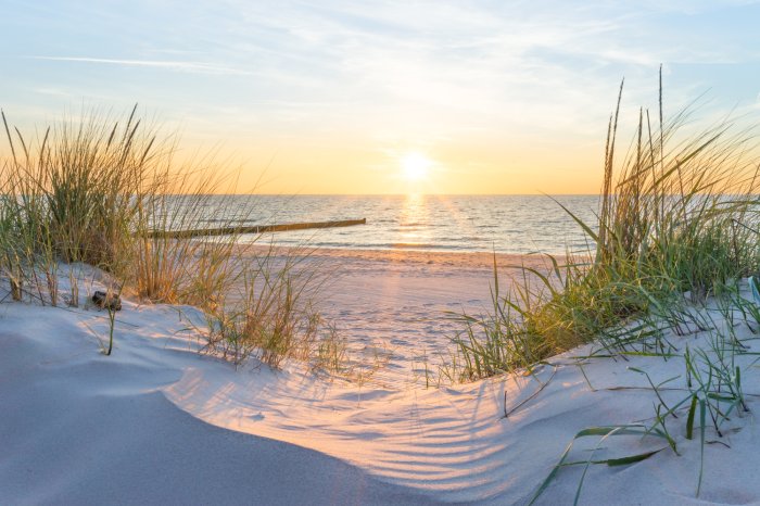 Fotobehang Zandduinen op het strand met uitzicht op de zee en de zonsondergang