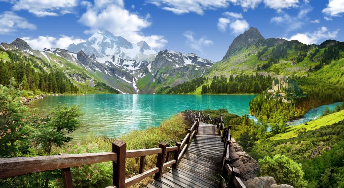 Fotobehang Landschap van een houten afdaling naar een bergmeer