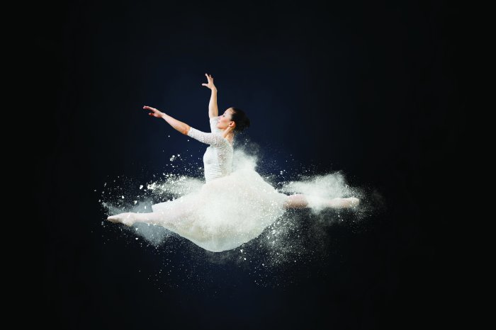 Fotobehang Een jonge vrouw in een witte jurk die de split doet