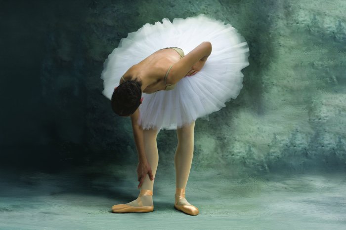 Fotobehang Een ballerina in een lichte rok tegen een betonnen achtergrond