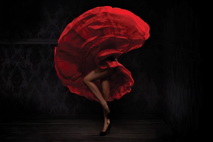 Fotobehang Een sensuele vrouw in een rode jurk die flamenco danst