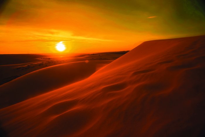 Fotobehang Gouden zonsondergang boven de uitgestrekte woestijn