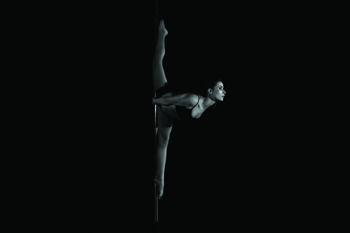 Fotobehang Een vrouw die de split doet tijdens een paaldans