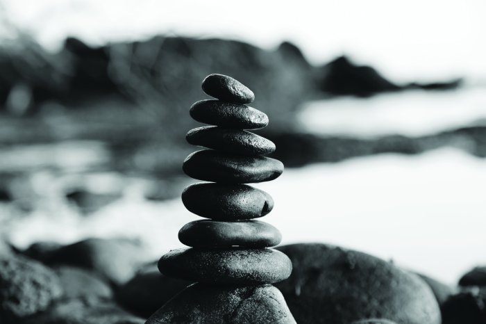 Fotobehang Zwarte en witte kiezels tegen de achtergrond van de zee