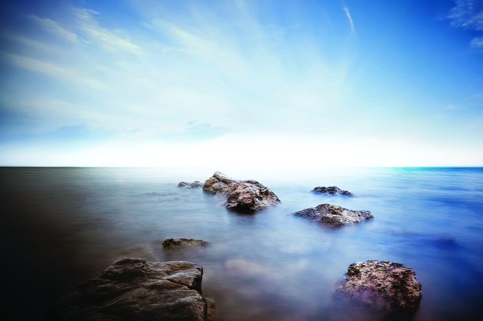 Fotobehang Rotsachtige stenen aan de kust