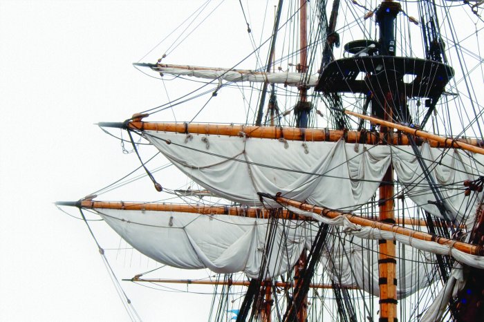 Fotobehang De zeilen van een enorm schip tegen een solide achtergrond