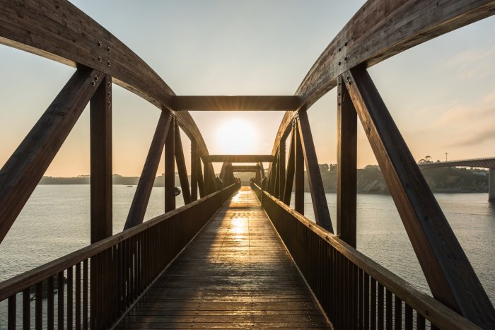 Fotobehang Houten brug over de rivier in het zonlicht