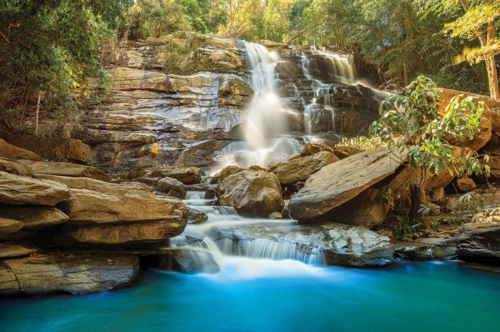 Fotobehang Een rivier met een stenen waterval in het bos