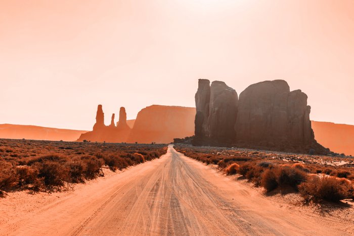 Fotobehang Een weg door een woestijn van zand en ruwe rotsen