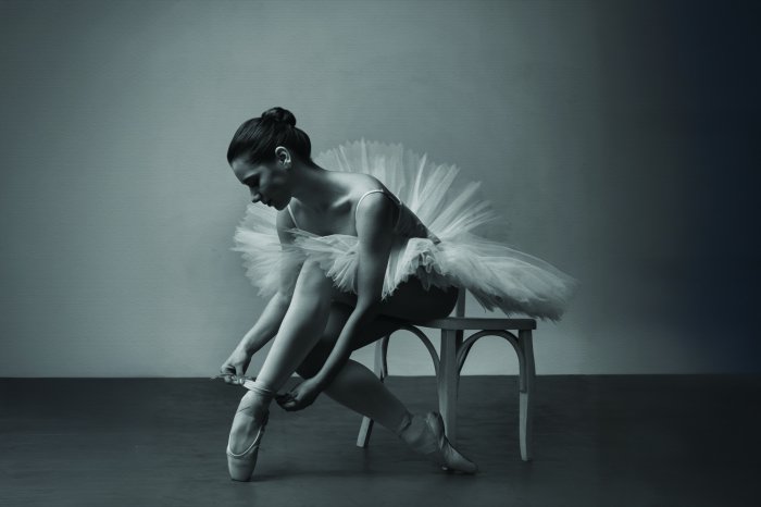 Fotobehang Een zwart-witfoto van een ballerina in een elegante pose.
