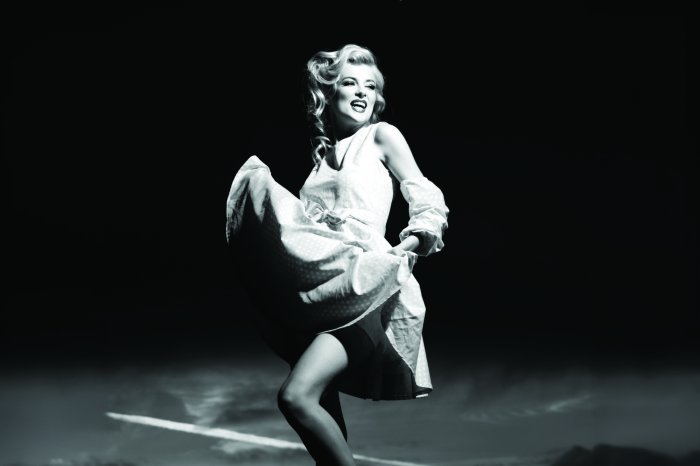 Fotobehang Een vrouw in een Monroe-jurk op een zwart-witfoto.