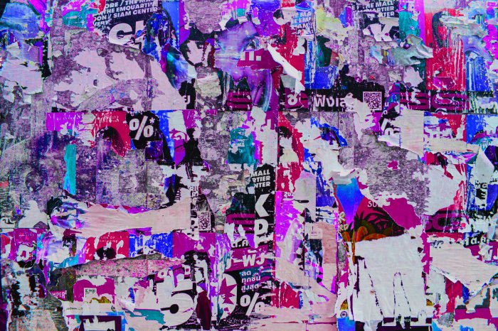 Fotobehang Een muur met restanten van roze en paarse posters