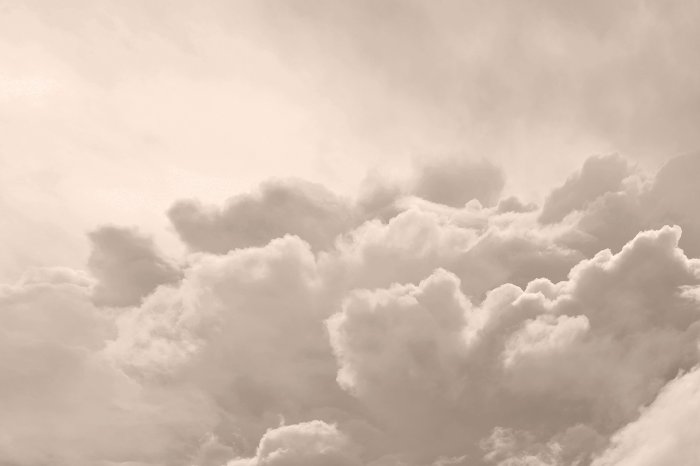 Fotobehang Beige lucht met donzige wolken