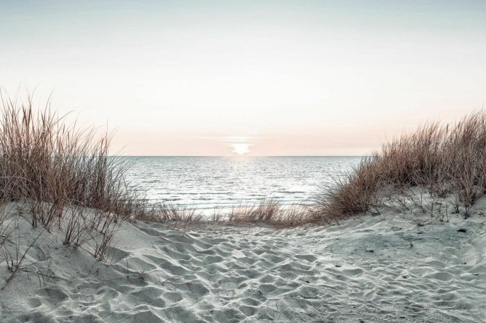 Fotobehang Zonsondergang over de zee en een zandstrand
