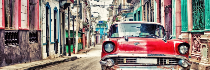 Canvas Een retro rode auto geparkeerd in de oude wijk van Havana