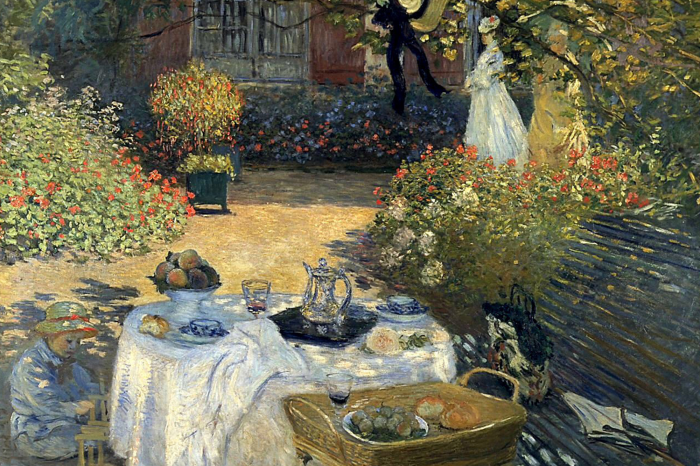 Canvas Een zomerse lunch in de tuin met bloeiende bloemen op de achtergrond