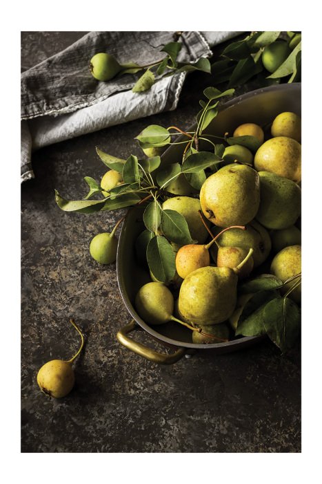 Poster Sappige peren in een minimalistische kom op de keukentafel