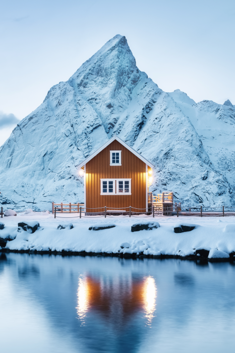 Poster Winterlandschap van een huis boven de berg