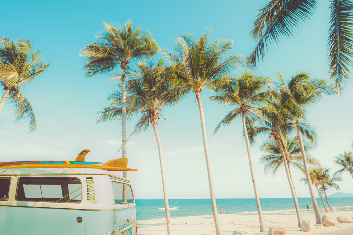 Poster Een camper met surfplank en palmbomen tegen de zee