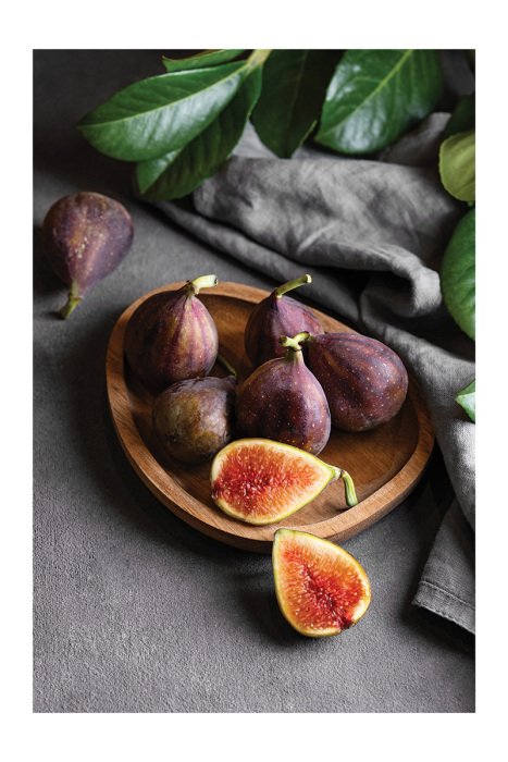 Poster Een natuurlijke compositie met vijgen en bladeren op het aanrecht