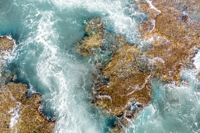 Poster Turquoise water over de stenen