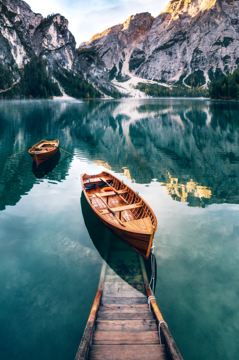 Poster Turquoise water van een bergmeer met een boot