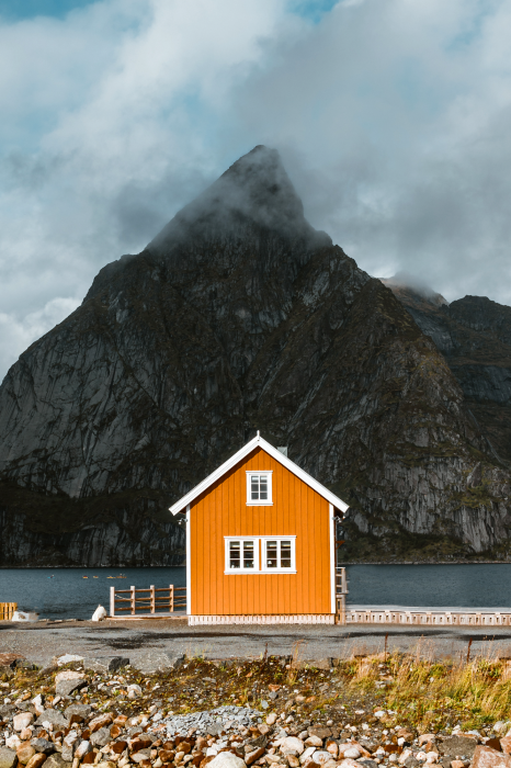 Poster Een oranje huis tussen de bergen en de oceaan