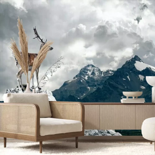 Fotobehang Een hert staat op een bewolkte dag op de top van een berg