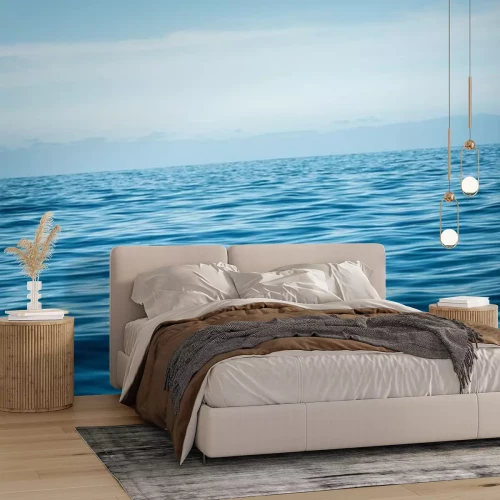 Fotobehang Een kalme oceaan tegen een blauwe lucht