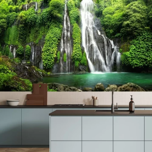 Fotobehang Een tropische waterval die in een turquoise vijver stroomt