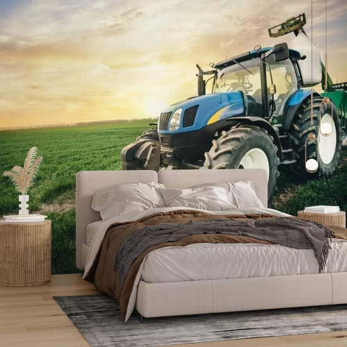 Fotobehang Een tractor met een zak kunstmest beweegt zich in het voorjaar langs het veld