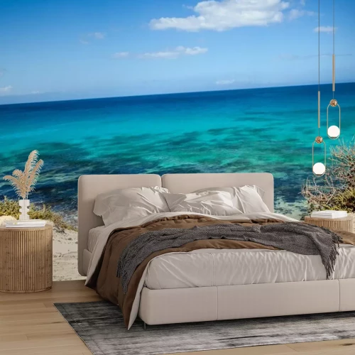 Fotobehang Turquoise zee met strand en blauwe lucht aan de horizon