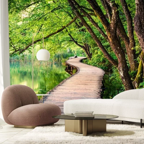 Fotobehang Een houten pad in een groen bos aan het meer