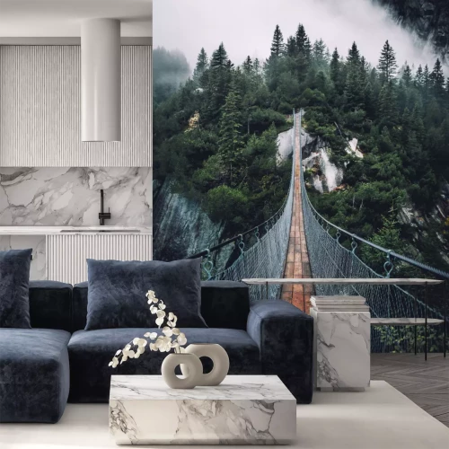 Fotobehang Hangbrug over een mistig bos