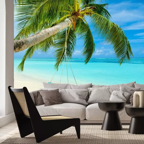 Fotobehang Palmboom met een schommel op een eiland