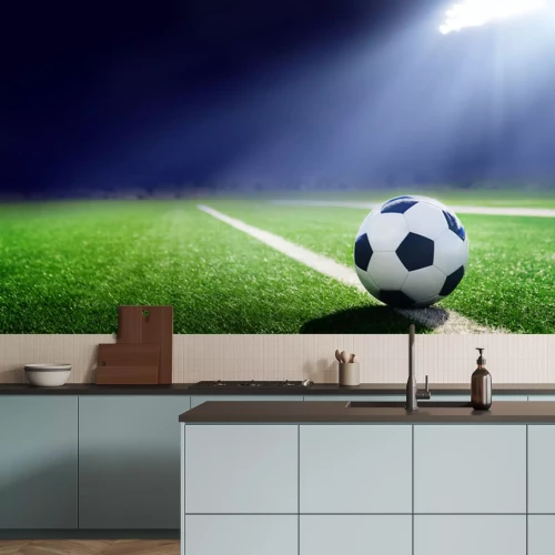 Sticker Een bal die op de grasmat ligt, verlicht door een schijnwerper