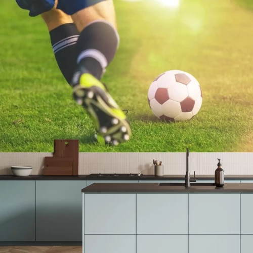 Sticker Voetballer rent naar de bal op de grasmat