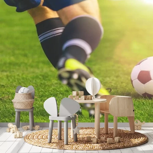 Sticker Voetballer rent naar de bal op de grasmat