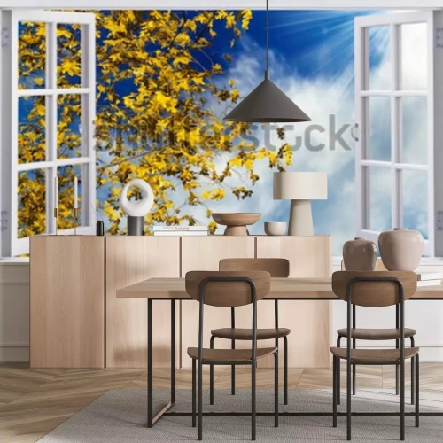 Fotobehang Uitzicht vanuit het raam op gele herfstbladeren en een blauwe lucht