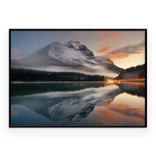 Poster Een meer dat de bergen en beboste hellingen weerspiegelt.