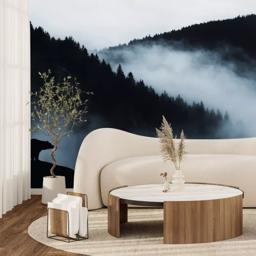 Fotobehang Nevelig bos met een silhouet van een beer