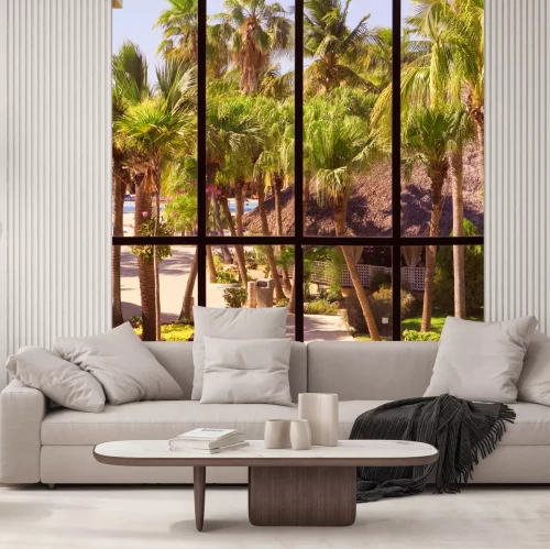 Fotobehang Uitzicht op een tropische tuin door een panoramisch raam