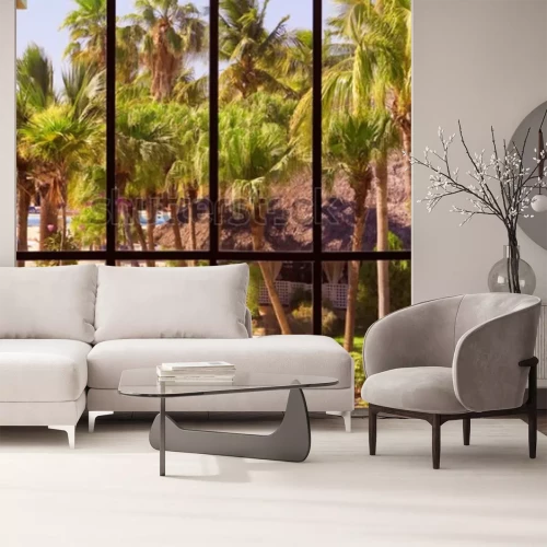 Fotobehang Uitzicht op een tropische tuin door een panoramisch raam