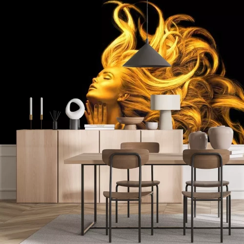 Fotobehang De figuur van een vrouw in gouden licht tegen een zwarte achtergrond