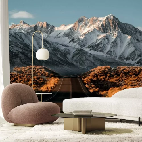 Fotobehang Landschap van een weg met besneeuwde bergtoppen op de achtergrond