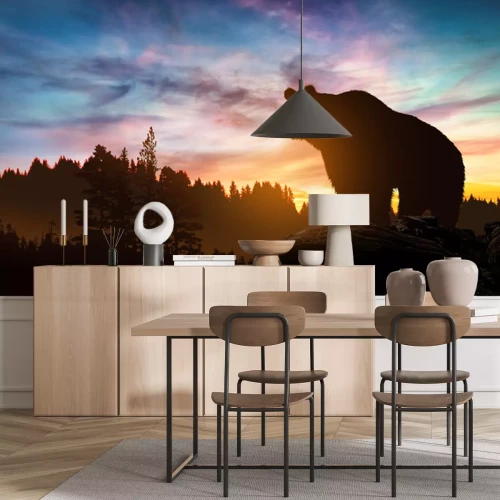 Fotobehang Een beer in een landschap met een zonsondergang op de achtergrond