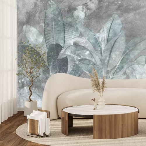 Fotobehang Groene tropische bladeren tegen een achtergrond van grijs beton