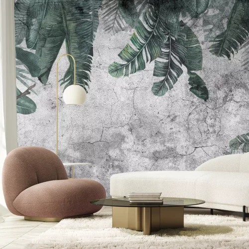 Fotobehang Tropische bladeren hangen aan een donkergrijze betonnen muur