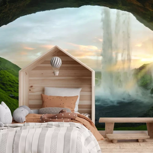 Fotobehang Uitzicht vanuit de grot op een natuurlijk landschap met een waterval