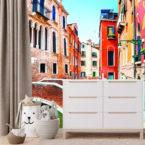 Fotobehang Een pittoresk kanaal met een brug omgeven door huurkazernes